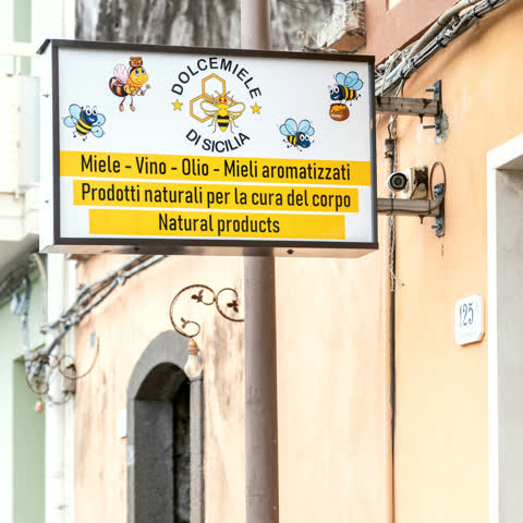 L'insegna della bottega con le api disegnate: miele, vino, olio, mieli aromatizzati